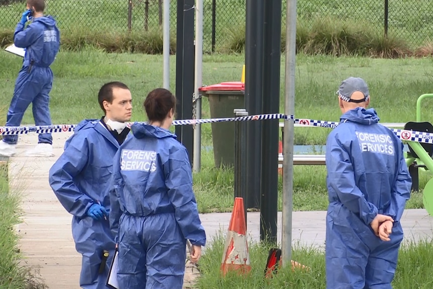 Police officers stand at crime scene