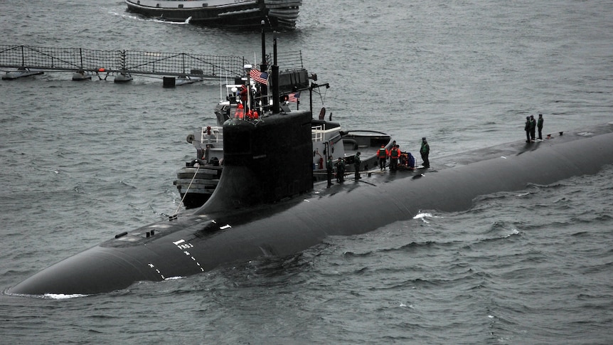 Semi submerged submarine with sailors visible on board. 