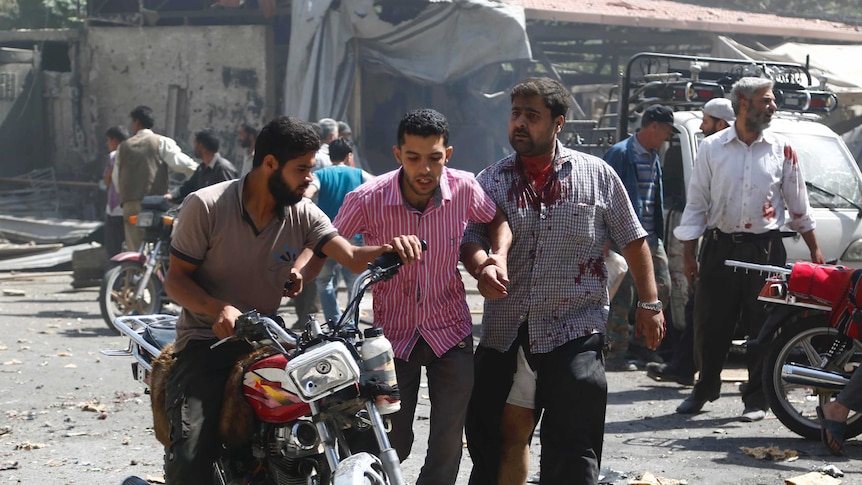 Syrian men react at the scene of reported air strikes near Damascus