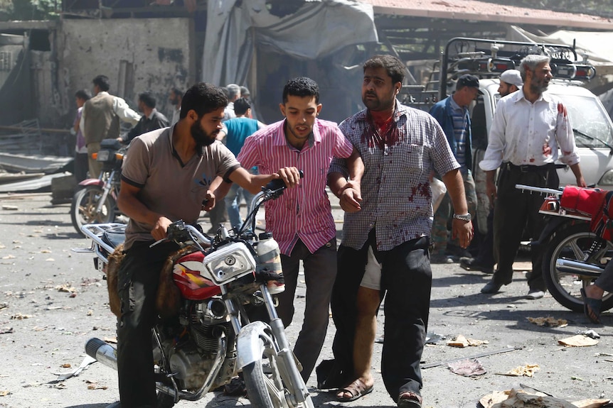 Syrian men react at the scene of reported air strikes near Damascus