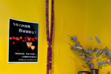 A poster with candles on it is put on a yellow wall
