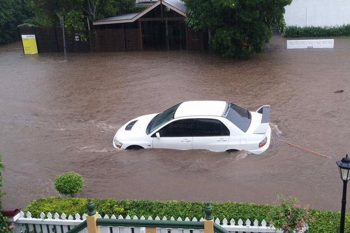 A car sitting in flood water outside a house in Paddington