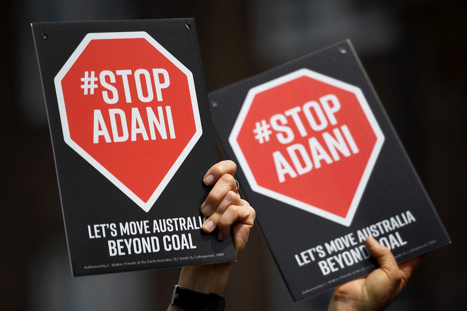 Close-up of Stop Adani signs held by protesters.