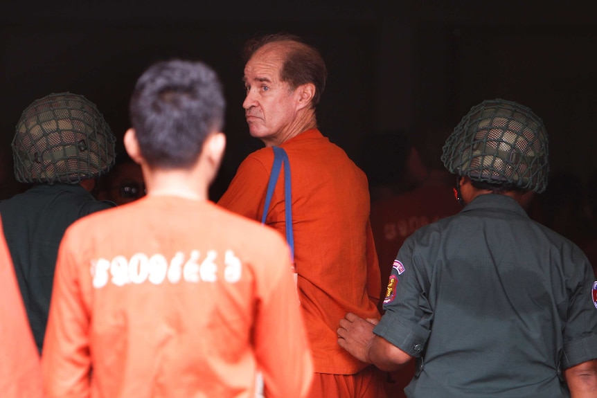 James Ricketson looks behind him as he walks into court