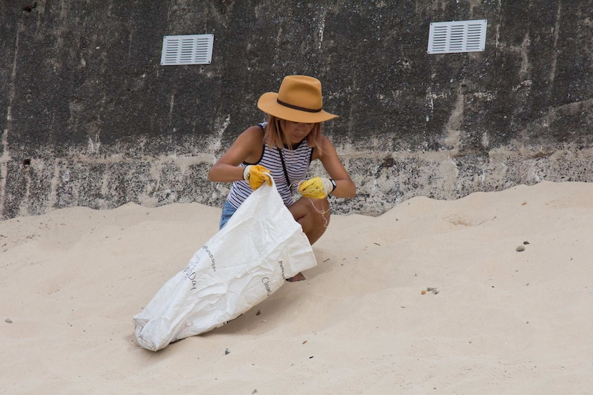 A volunteer collects rubbish at Bondi Beach