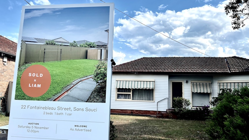 A real estate sign in the front yard of a house in Sydney's south, with a sold sticker on it.