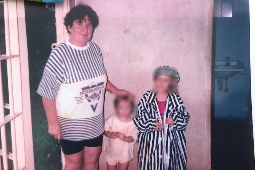 A photograph of woman Fran Hodgetts standing next to two children