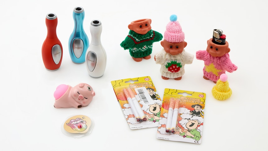 A bunch of toys, including fake cigarettes displayed with a white background