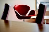 A red chair in a boardroom.