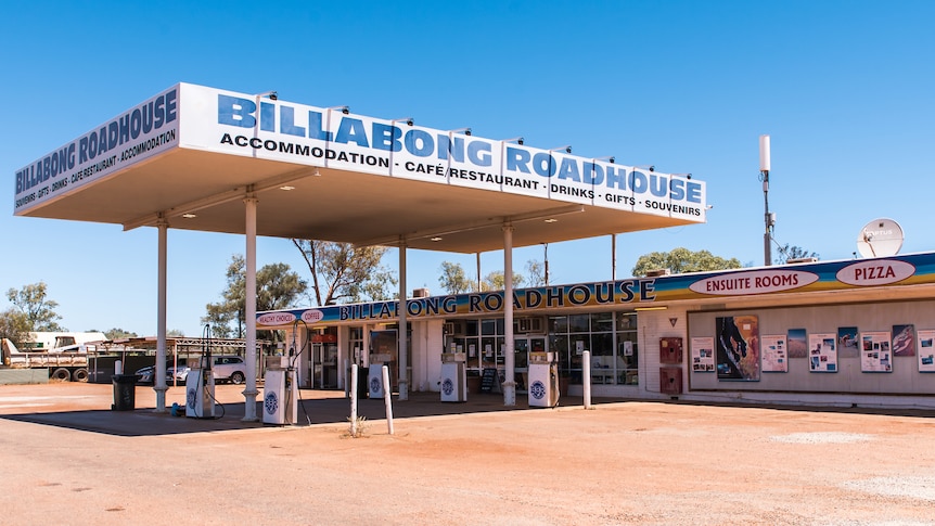 A roadhouse with large forecourt against a big blue sky