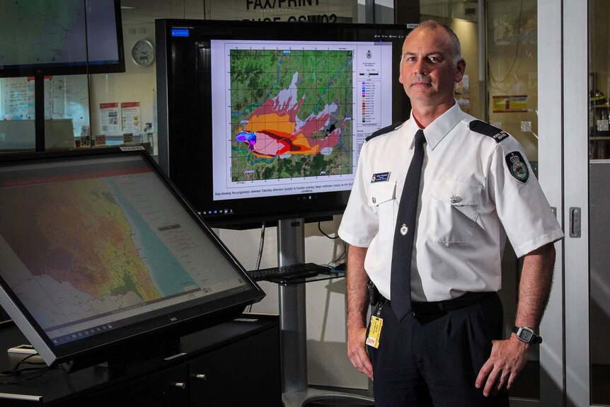 Simon Heemstra stands besides large touch screens at the RFS headquarters