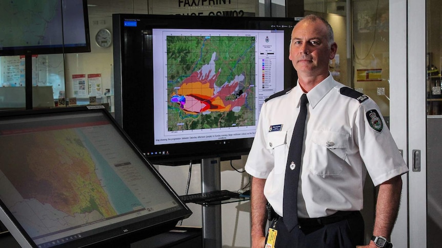 Simon Heemstra stands besides large touch screens at the RFS headquarters