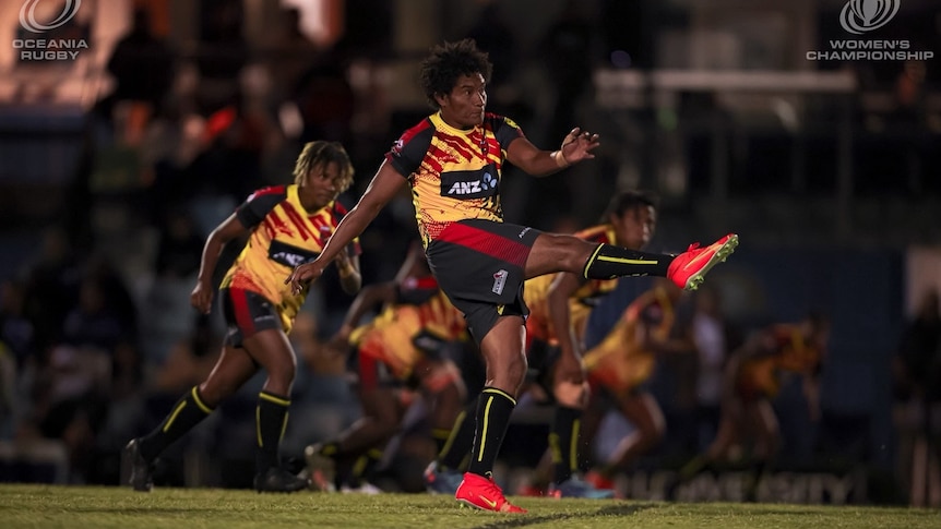 PNG captain of the women's rugby team kicks the ball
