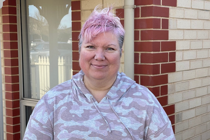 A woman with short pink hair