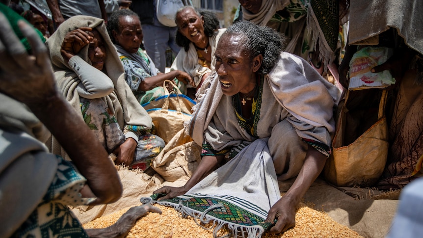 An Ethiopian woman argues with others over the allocation of yellow split peas.