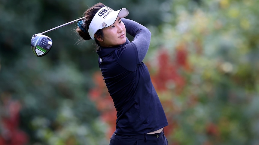 An Australian female golfer watches a tee shot.