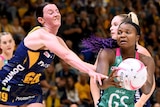Two Super Netball players challenge for the ball during the match.