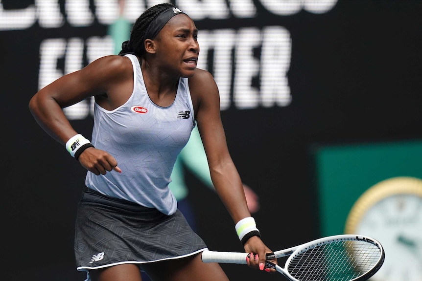 A female tennis player pumps her fist as she celebrates winning a point in a match at the Australian Open.