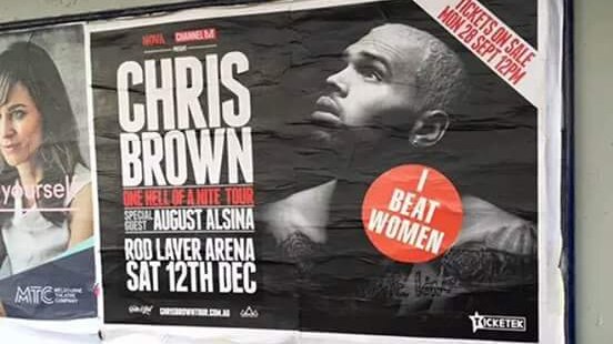 'I Beat Women' sticker on Chris Brown poster