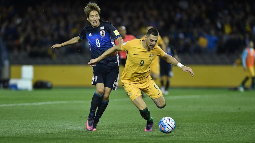 Japan's Genki Haraguchi (L) concedes a penalty to Australia's Tomi Juric in World Cup qualifier.