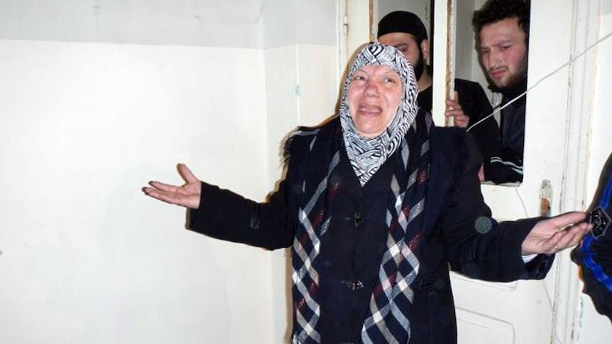 Syrian woman reacts after leaving morgue housing victims of alleged massacre