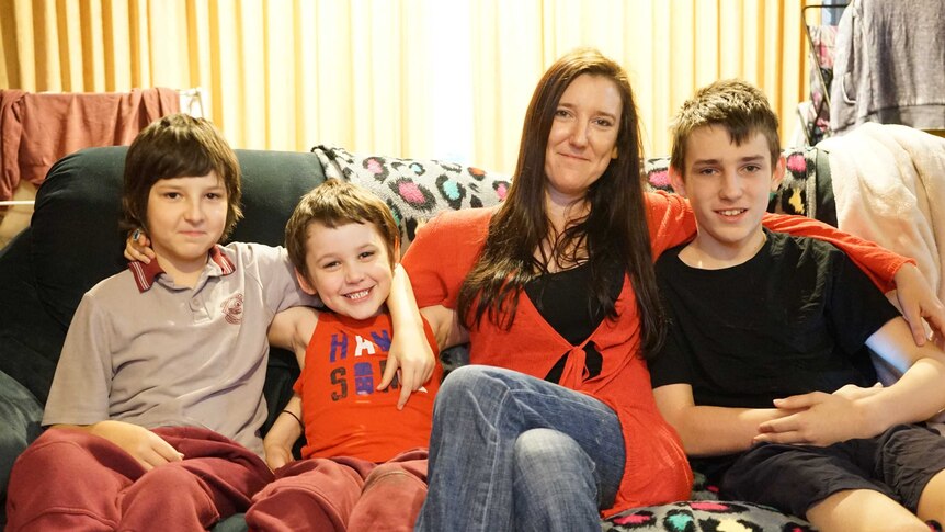 Rachel Grimshaw and her three sons sitting on the sofa in their lounge
