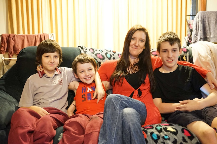 Rachel Grimshaw and her three sons sitting on the sofa in their lounge