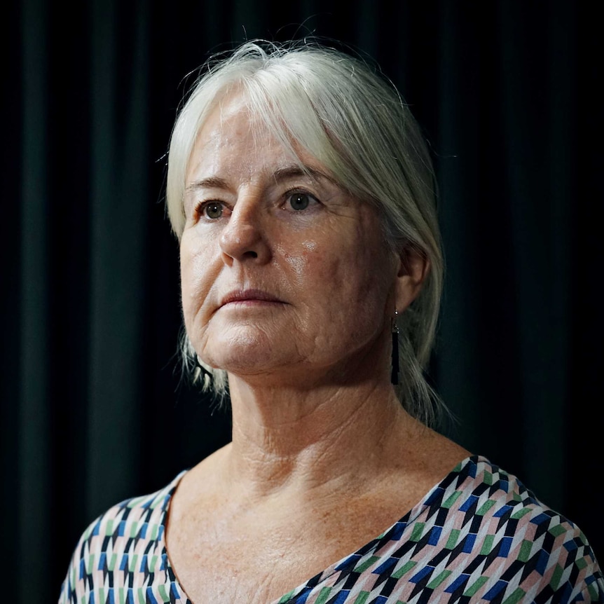 Lauren Hill, from the NT Police sex crime division, standing against a black curtain.