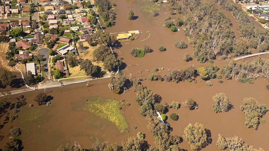 An aerial photo of a town flooded with brown water.