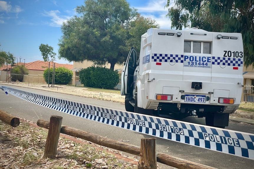 A police car on a cordoned off street 