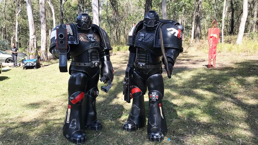 Two people dressed in Transformers-style costumes holding gel ball blasters for game of Gel ball on Gold Coast.