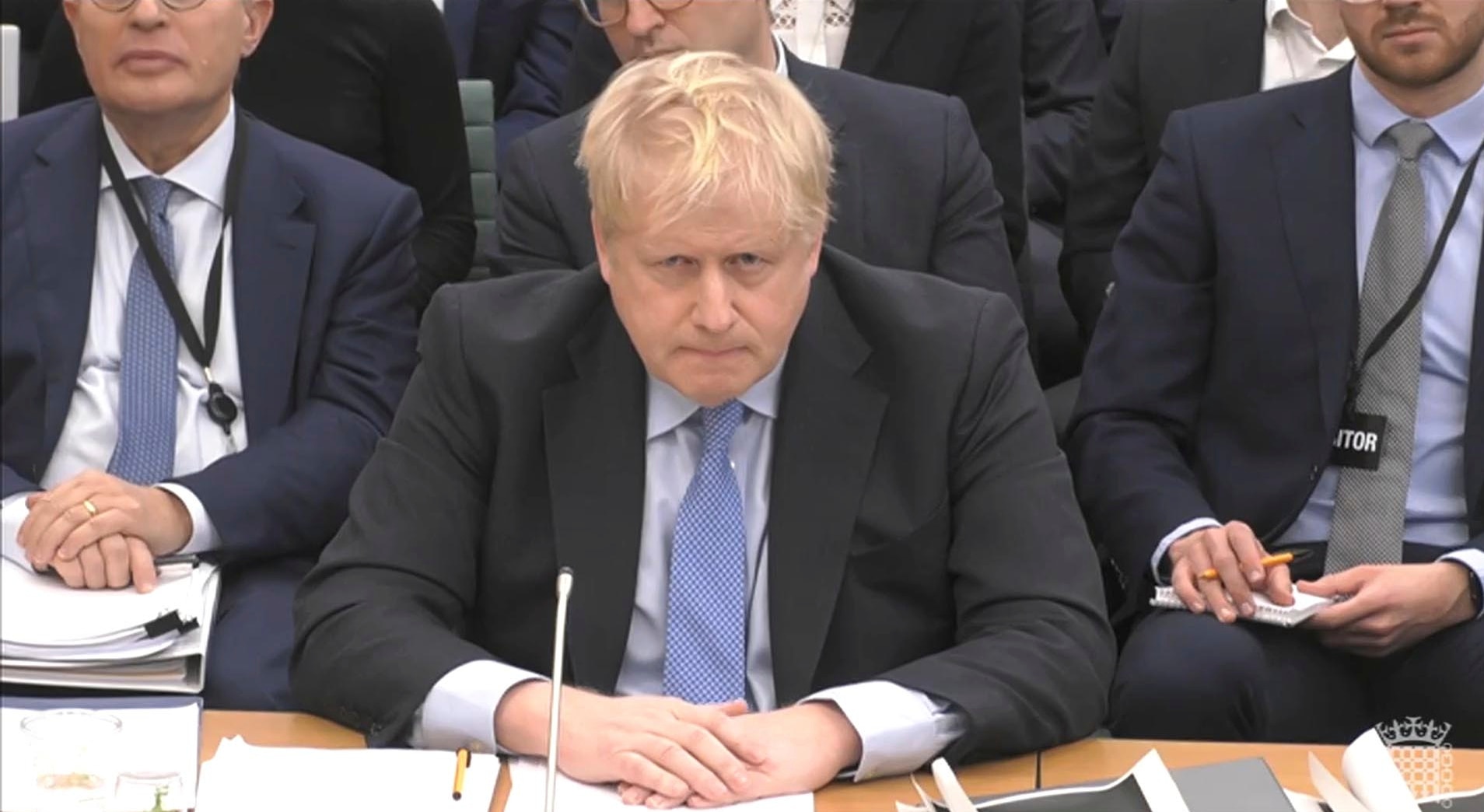 Mr Johnson sits with his arms folded over a desk