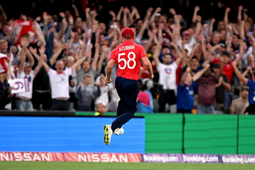 Sam Curran leaps in the air and celebrates in front of England's support 