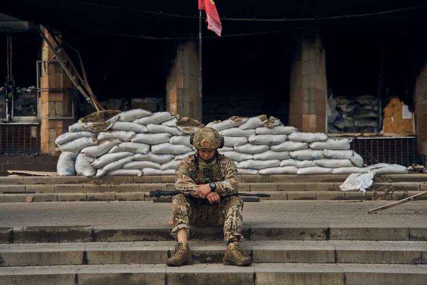 A Ukrainian soldiers rests as Rusian troops go on a retreat in the northeast.