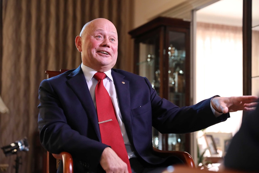 Grigory Logvinov sits in a chair speaking in an interview.