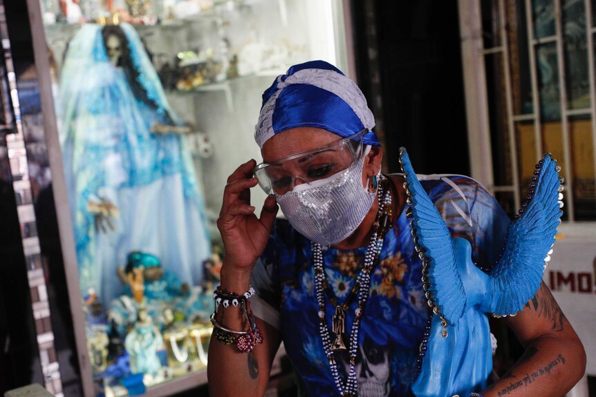 A woman adjusts her protective goggles as she leaves after visiting an altar to the "Santa Muerte," or Death Saint.