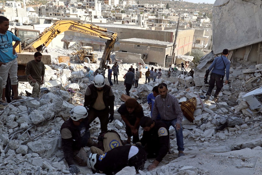 Civil defence members search for survivors under the rubble of a site hit by overnight airstrikes in Aleppo.