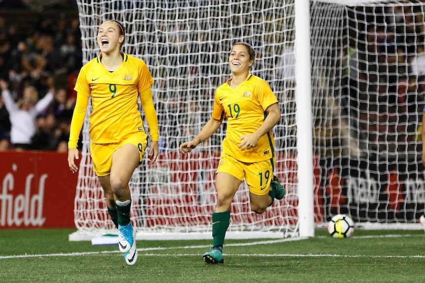 Caitlin Foord running away from goal with a smile on her face after scoring against Brazil.