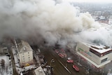 An aerial shot shows smoke billowing from a shopping centre in siberia