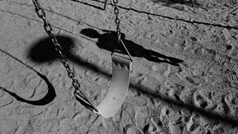 Empty swing with shadow of a child (Thinkstock:  iStockphoto)