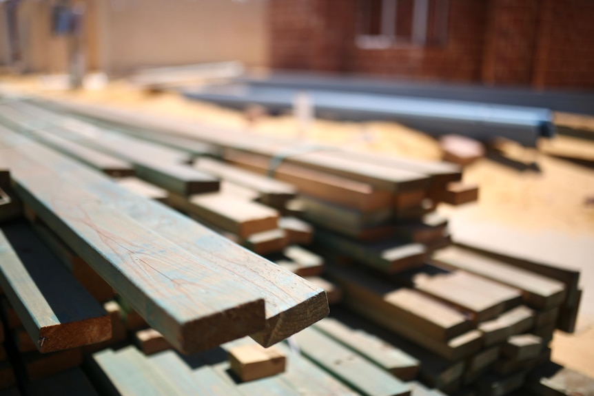 A pile of wooden beams at a building site