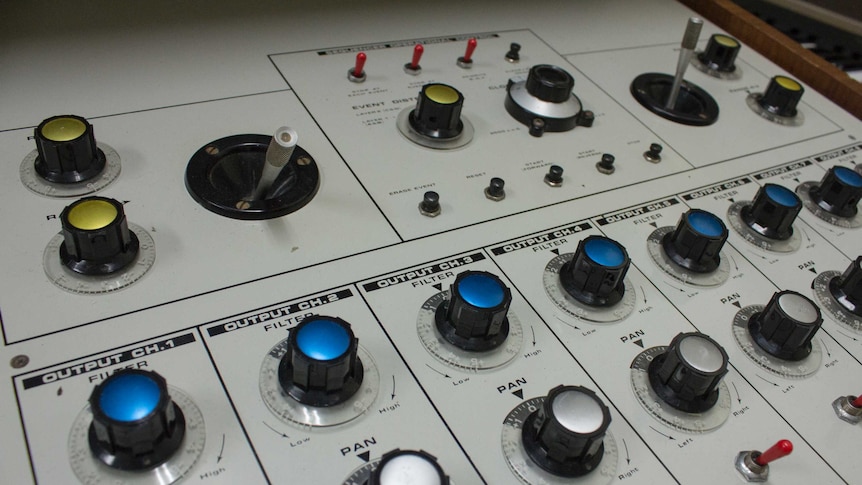 A grey panel  covered in dials and switches.