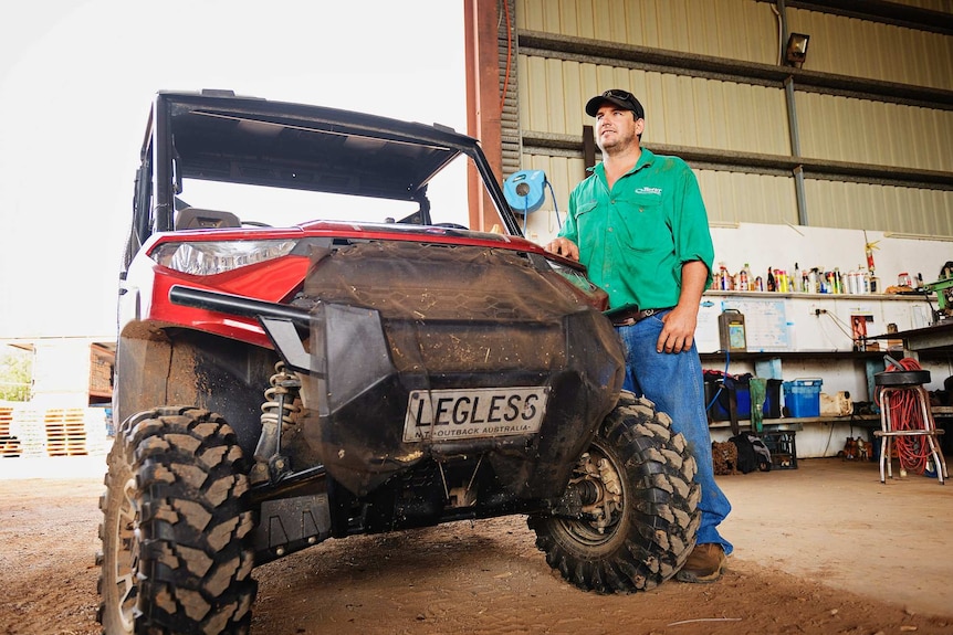 Gavin Howie stands next to a farming vehicle with the numberplate 'legless'