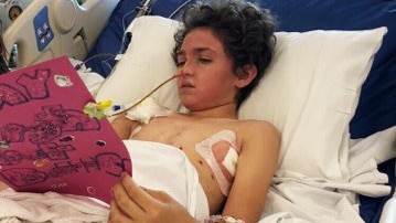 Connor Creagh in a hospital bed at the Queensland Children's Hospital after being crushed by a tree in October 2018.