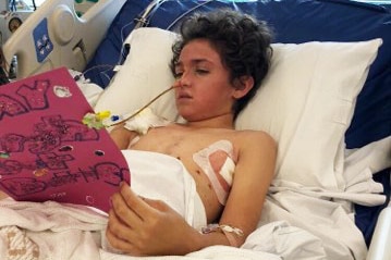 Connor Creagh in a hospital bed at the Queensland Children's Hospital after being crushed by a tree in October 2018.