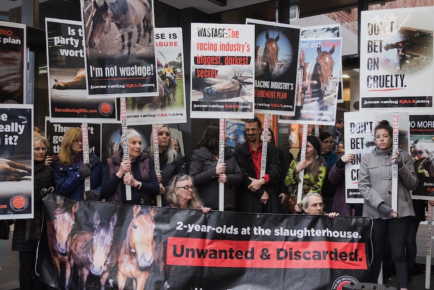 Anti-racing protesters hold placards outside the premiere screening of the new film Ride Like a Girl.