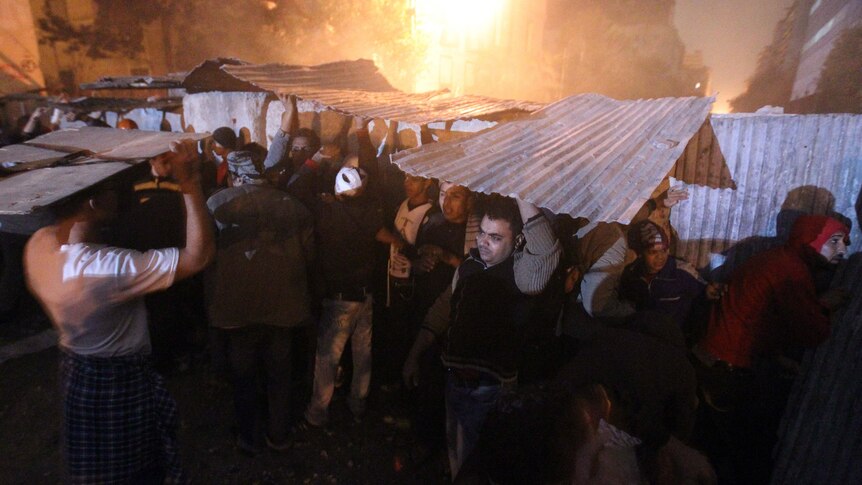 Egyptian protesters take cover during clashes