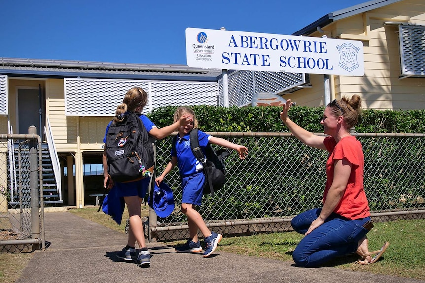 Michele Coventry waves goodbye to her two daughters who enter the gates of Abergowrie State School