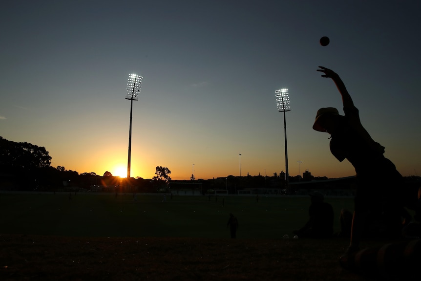 A file photo a child in silhouette playing cricket.