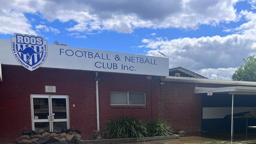 A sports club building with some water inundation to the side